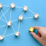 Building a successful team with wooden blocks showing people icons on a blue background, teamwork concept.